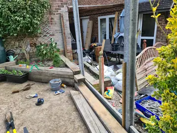 A patio being rebuilt, with new timber frames and paving in progress