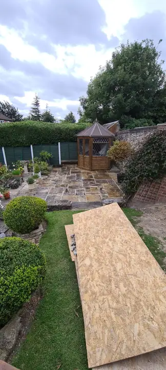 A garden path being laid with boards beside a patio