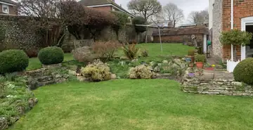 A landscaped garden with lawn, rockery and clipped shrubs
